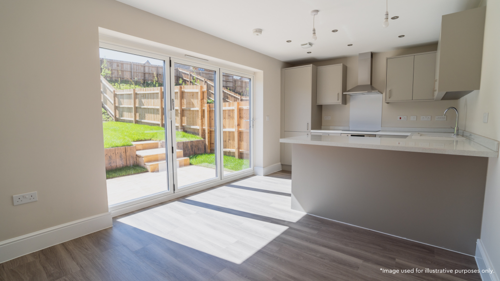 Neutral kitchen with bi-fold doors leading to the garden